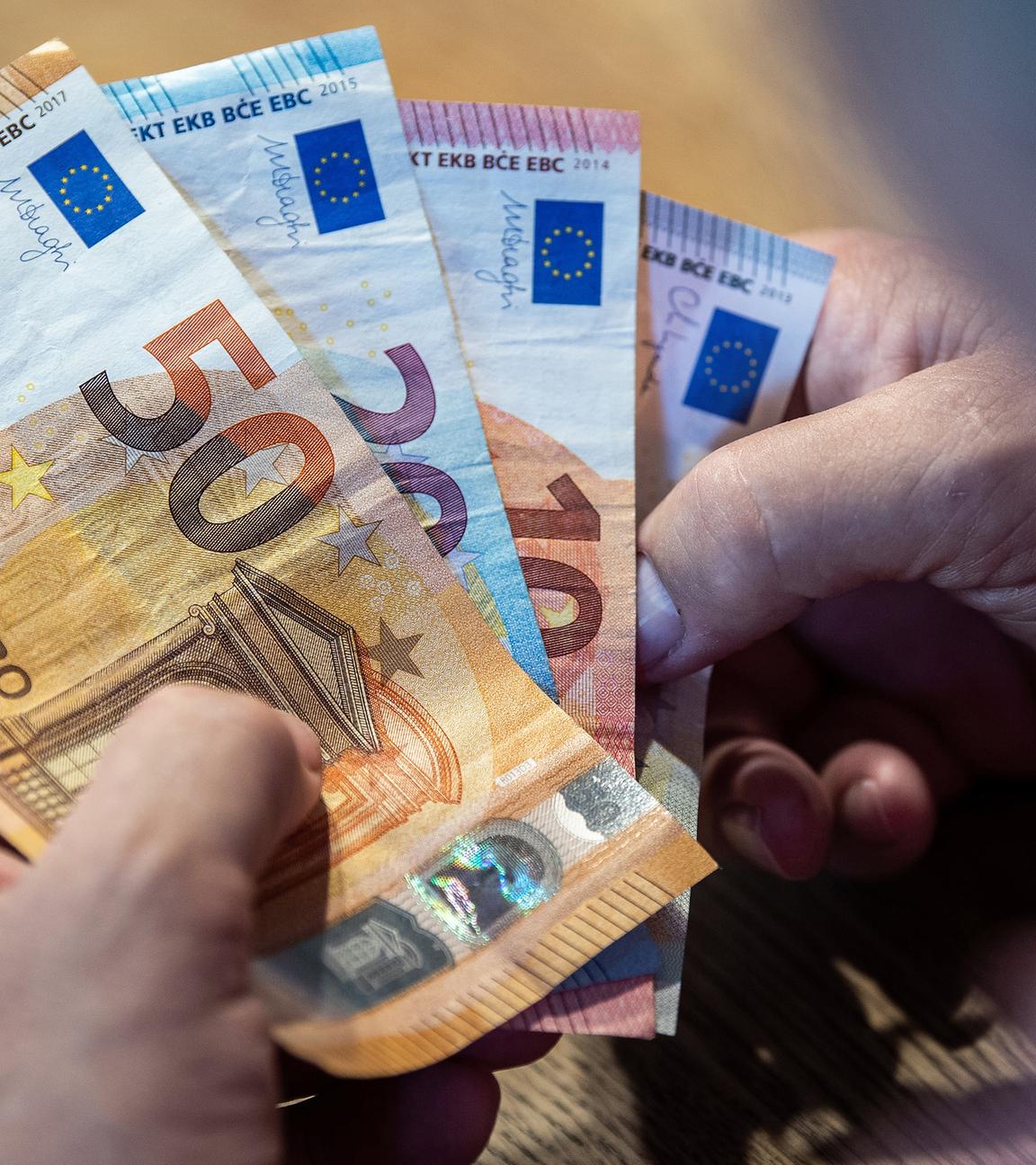 Ein Mann sitzt an einem Tisch und zählt Geld, aufgenommen am 11.08.2021