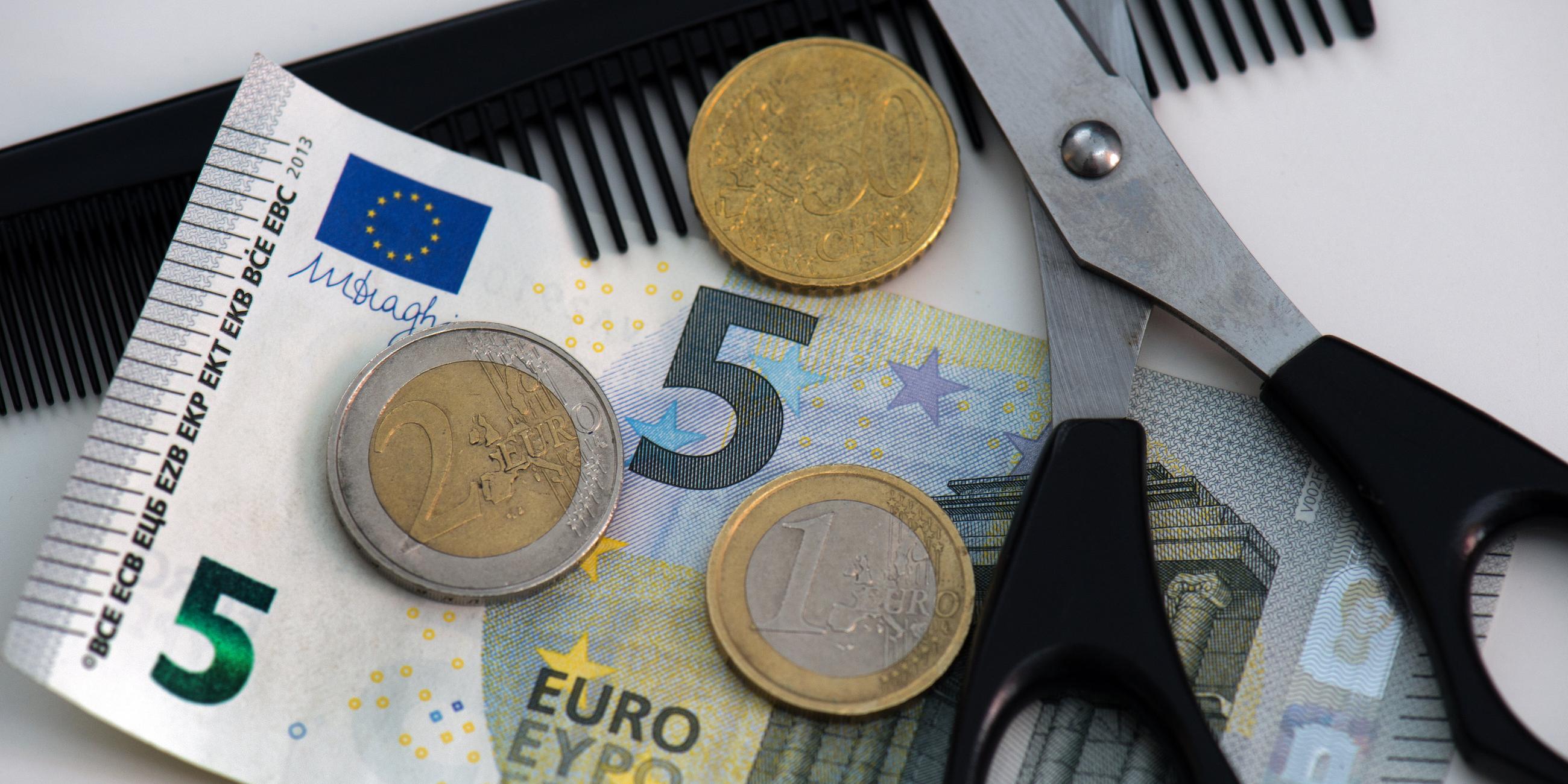 Neben einer Schere und einem Kamm liegen 8,50 Euro.