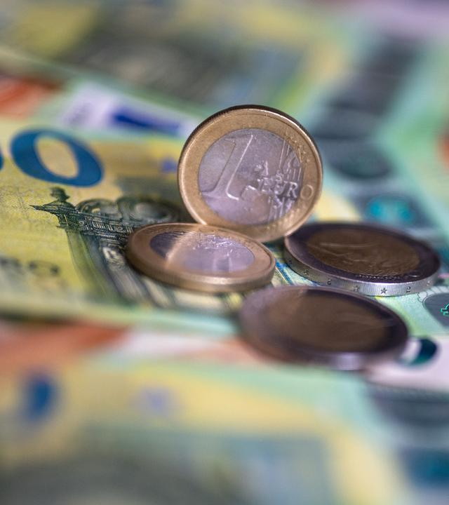 Geldscheine mit dem Wert von 100 und 50 Euro und Münzen liegen auf einem Tisch.