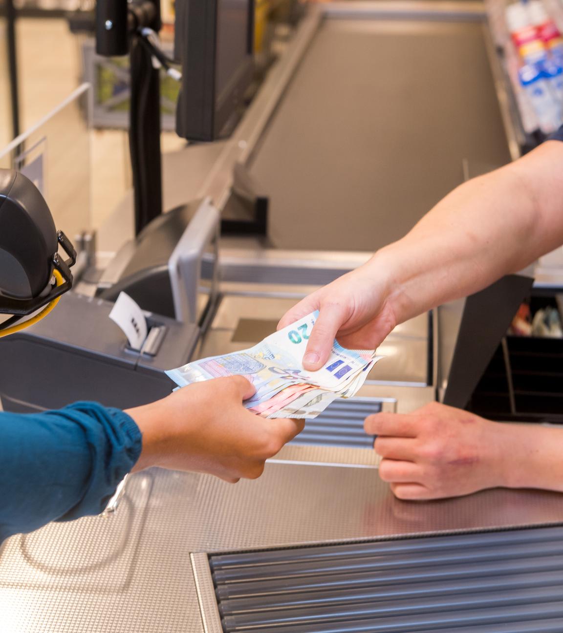 Schleswig-Holstein, Flensburg: In einem Supermarkt hebt eine Kundin beim Bezahlen auch gleich Bargeld ab. Archivbild