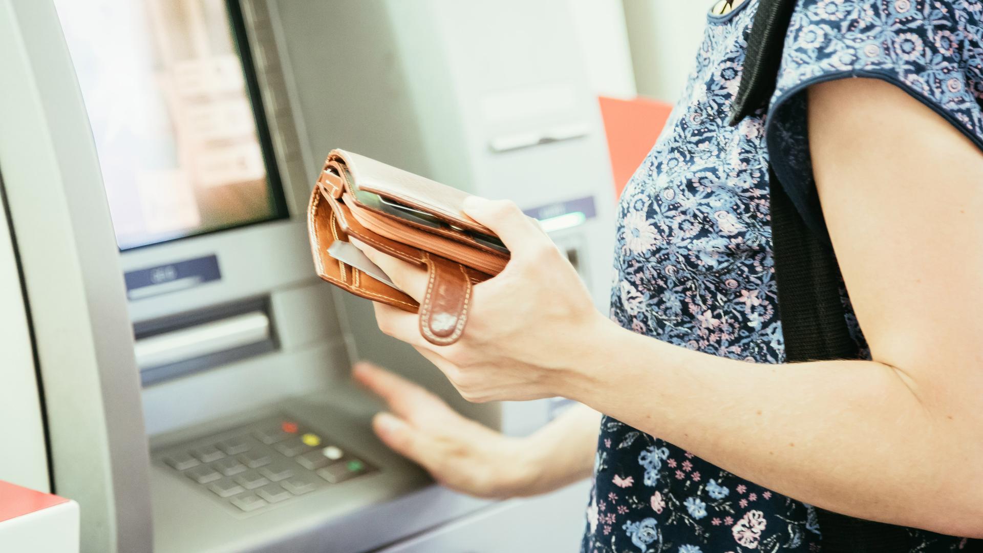 Eine Frau steht vor einem Geldautomat, 14.12.2019.