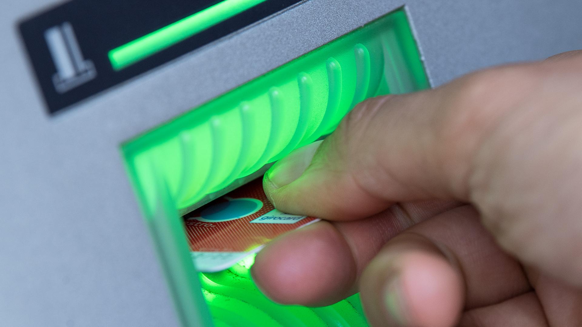 Eine Bankkarte steckt in einem Geldautomaten.