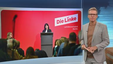 Moderator Ralph Szepanski vor einem Bild von Elif Eralp von der Linken Berlin.