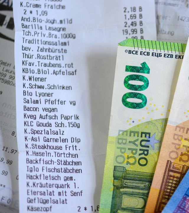 Sachsen, Leipzig: Geldscheine liegen auf Kassenzettel.