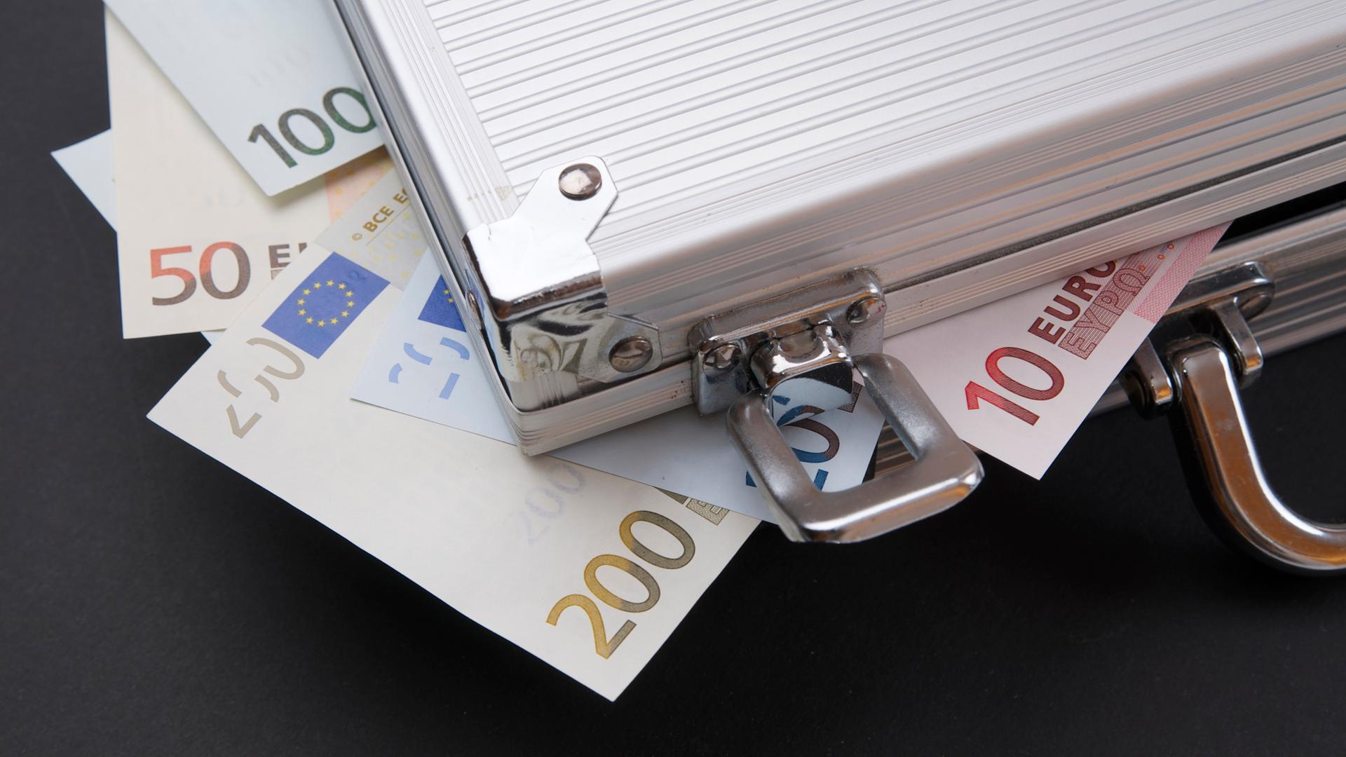 Archiv: Geldscheine quillen aus einem Aktenkoffer