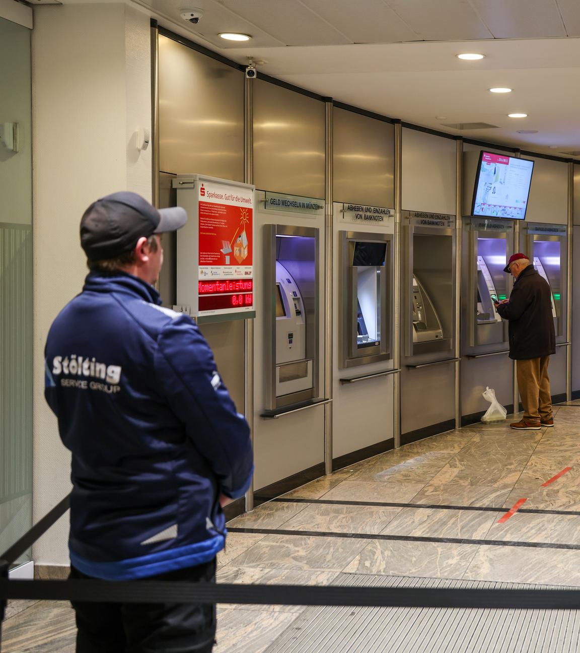 Gelsenkirchen: Mitarbeiter einer Sicherheitsfirma stehen im nun wieder geöffneten SB-Bereich der Sparkassenfiliale