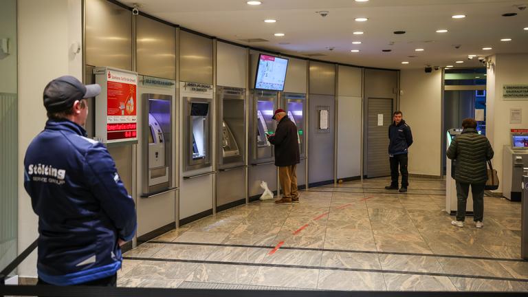 Gelsenkirchen: Mitarbeiter einer Sicherheitsfirma stehen im nun wieder geöffneten SB-Bereich der Sparkassenfiliale