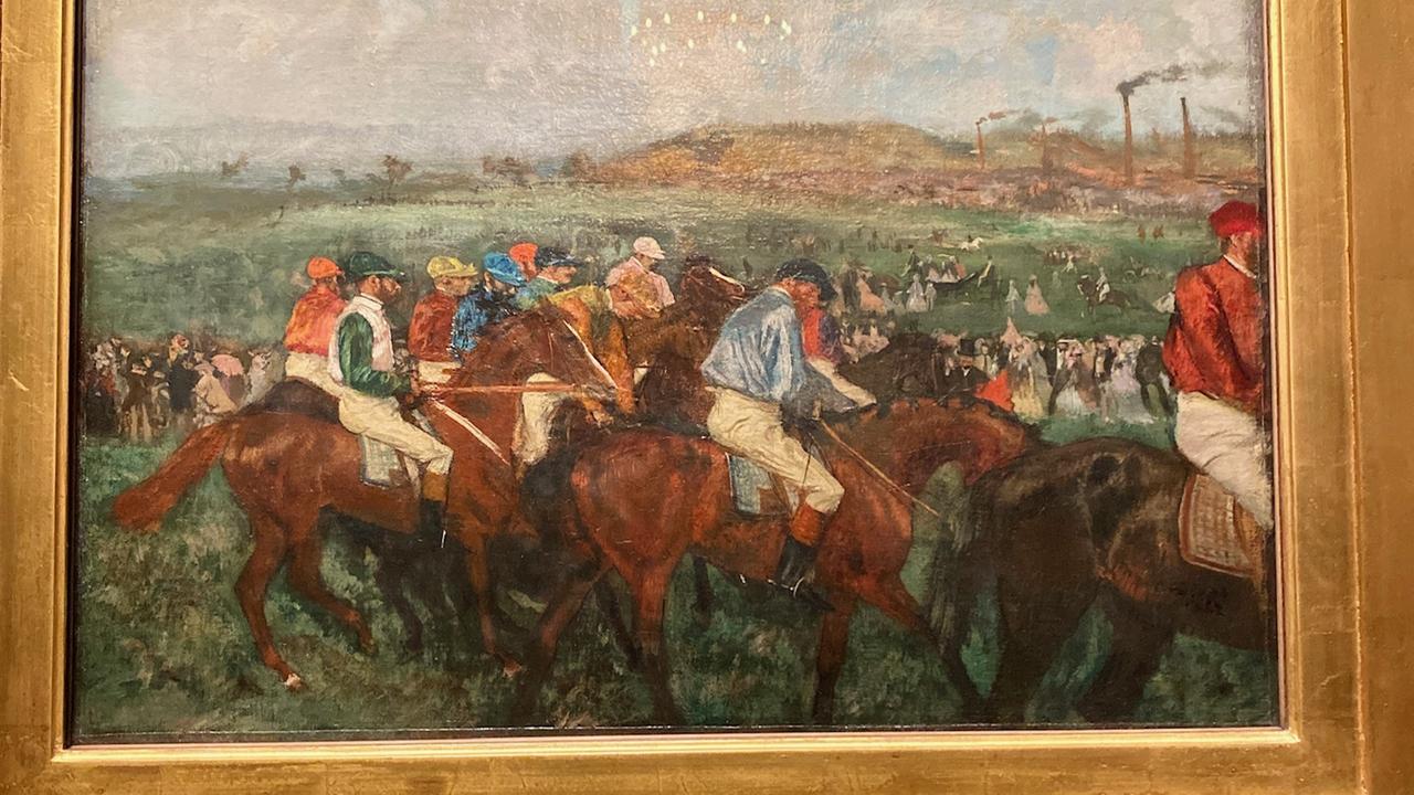 Eine Masse von Männern reitet auf Pferden. Im Hintergrund ist eine weite Landschaft aus grünen Hügeln zu sehen.