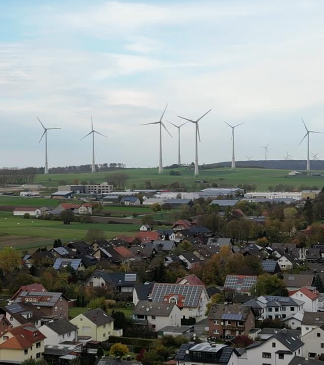 Windräder in Nachbarschaft zu einer Ortschaft