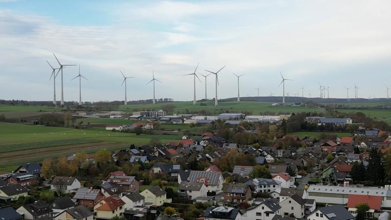 Windräder in Nachbarschaft zu einer Ortschaft