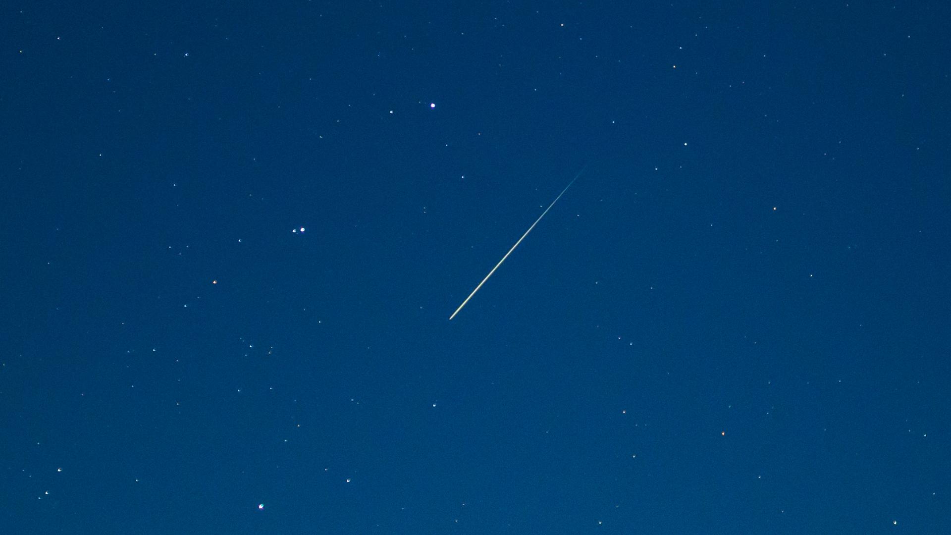 14.12.2024, Brandenburg, Lietzen: Eine Sternschnuppe leuchtet am Nachthimmel.