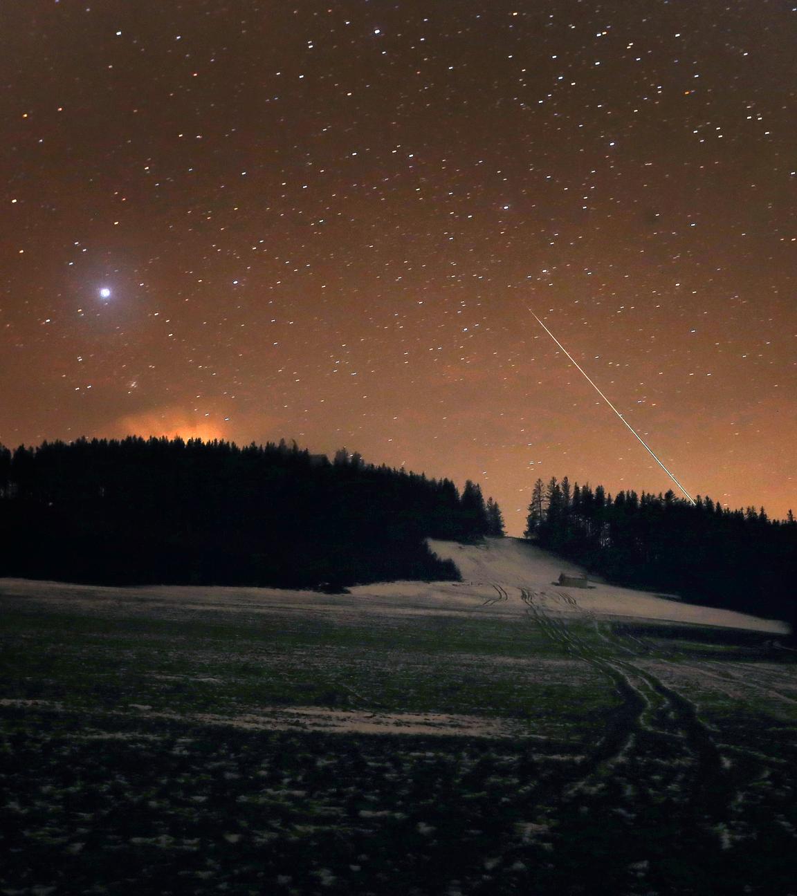13.12.2020, Bayern, Stötten: Eine Sternschnuppe verglüht am Nachthimmel über dem Auerberg.