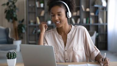 Junge Frau der Gen Z arbeitet am Laptop