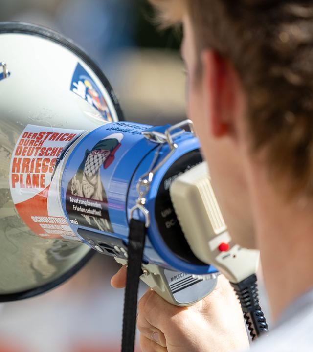 Ein junger Mann ruft in ein Megafon hinein während eines Schulstreikes gegen die Wehrpflicht am 25.09.2026 in Witten.