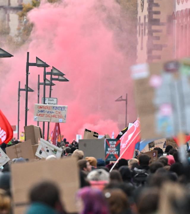 Teilnehmer der Demonstration ziehen durch die Innenstadt und zünden Pyrotechnik.
