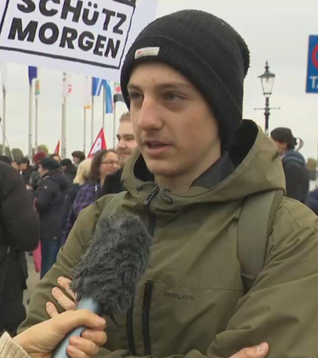 Ein junger Mann spricht in ein Mikrofon. 