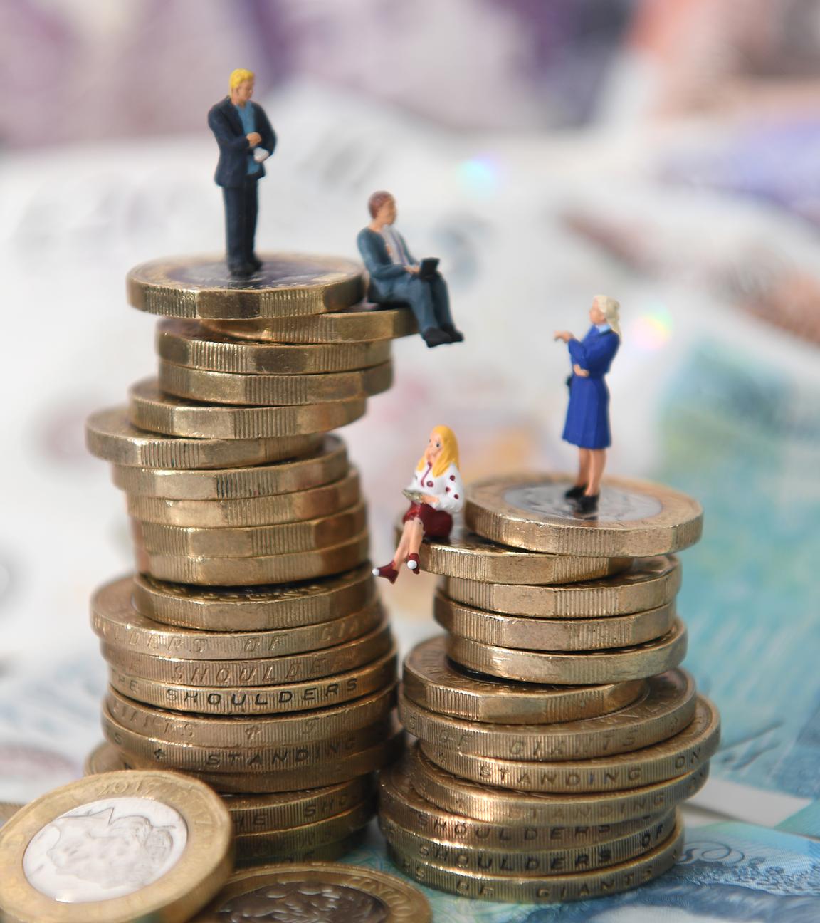 Es sind zwei Türme aus Münzen erkennbar, die symbolisieren, dass Männer mehr verdienen