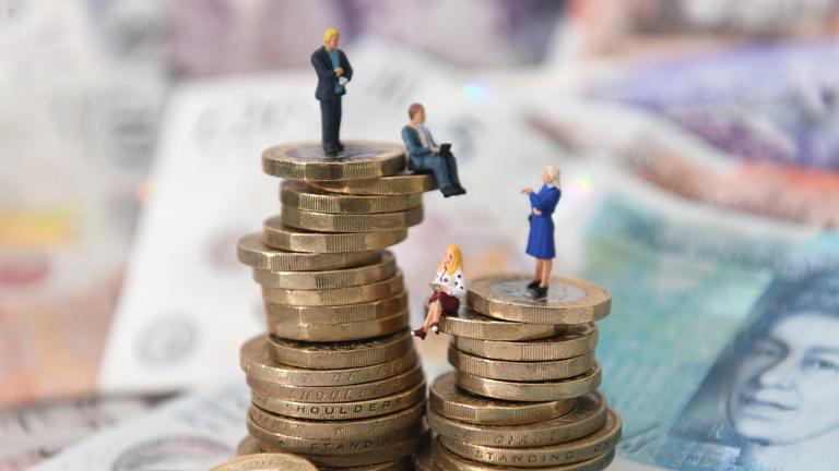 Es sind zwei Türme aus Münzen erkennbar, die symbolisieren, dass Männer mehr verdienen