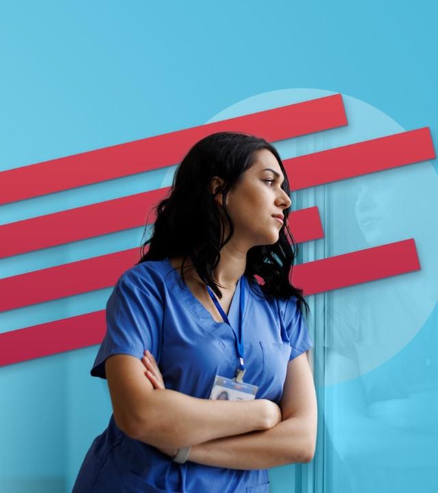 Eine Krankenpflegerin mit blauem Kasack und umgehängtem Namensschild verschränkt die Arme.