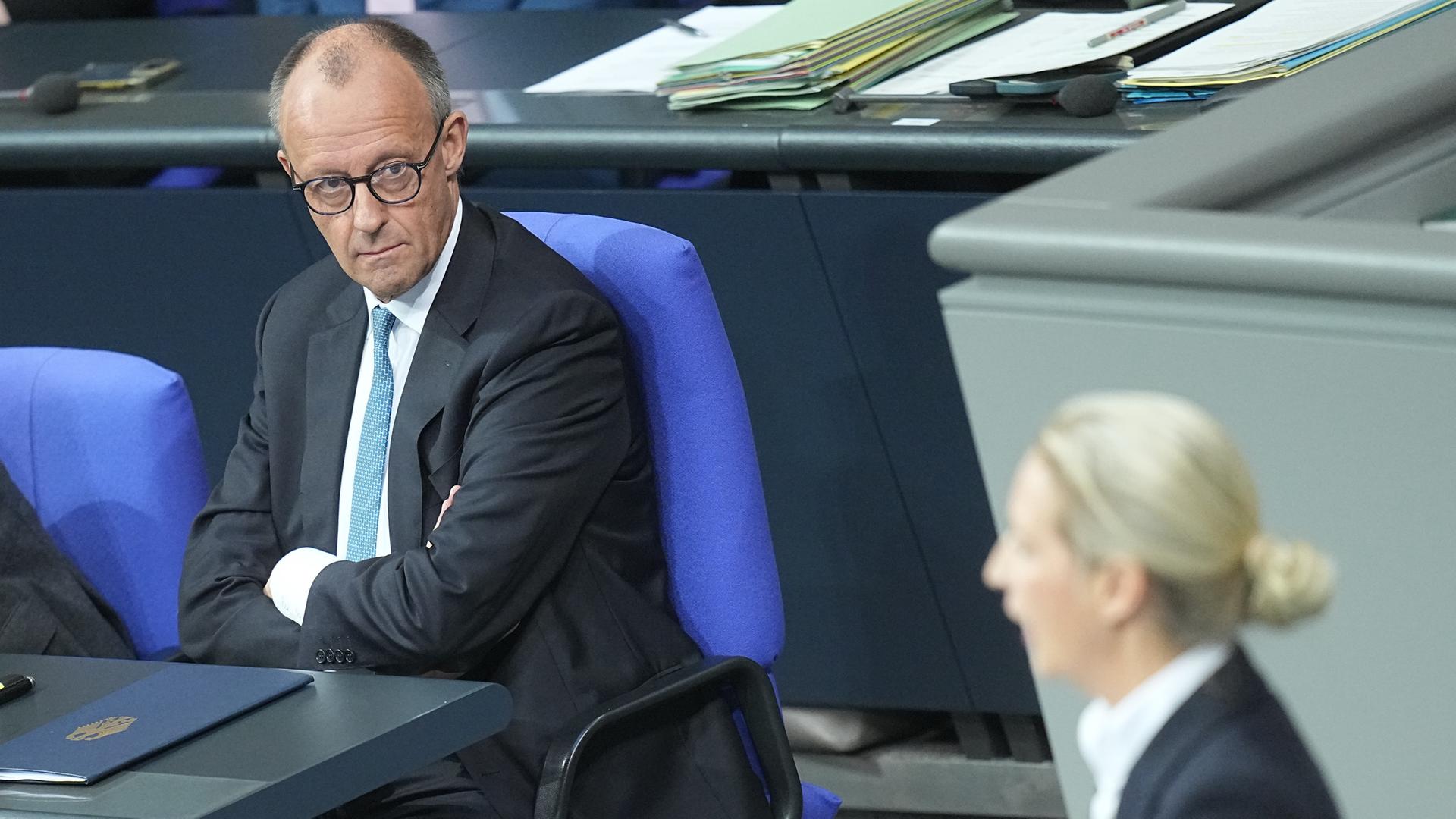 Bundeskanzler Friedrich Merz (CDU) schaut zu Alice Weidel, Fraktions- und Bundesvorsitzende der AfD, während sie in der Generaldebatte im Bundestag zum Haushalt spricht. 