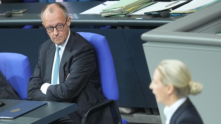 Bundeskanzler Friedrich Merz (CDU) schaut zu Alice Weidel, Fraktions- und Bundesvorsitzende der AfD, während sie in der Generaldebatte im Bundestag zum Haushalt spricht. 