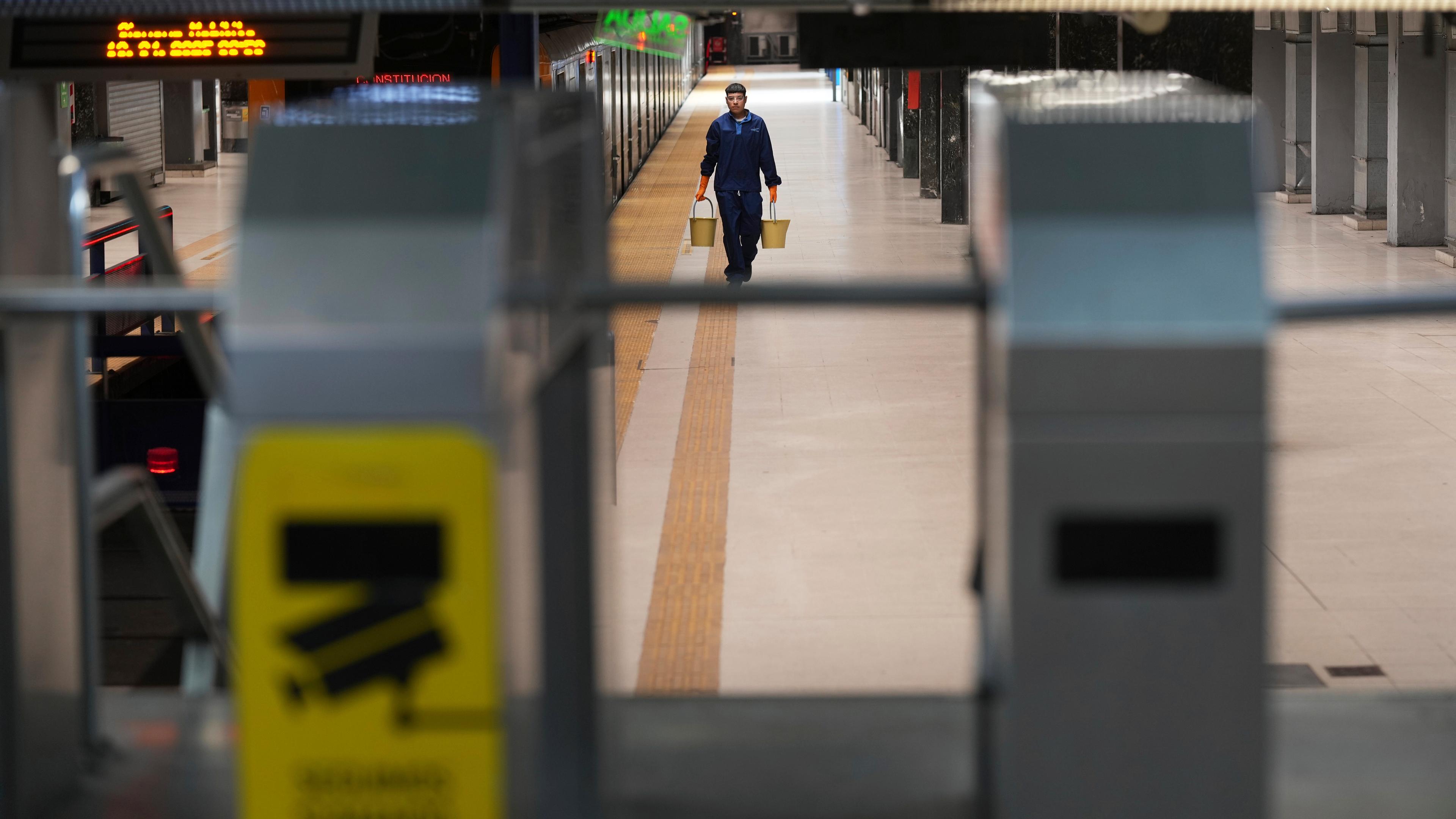Argentinien, Buenos Aires: Ein einsamer Arbeiter geht während eines Generalstreiks gegen die Sparmaßnahmen von Präsident Milei durch die U-Bahn-Station Consititucion.