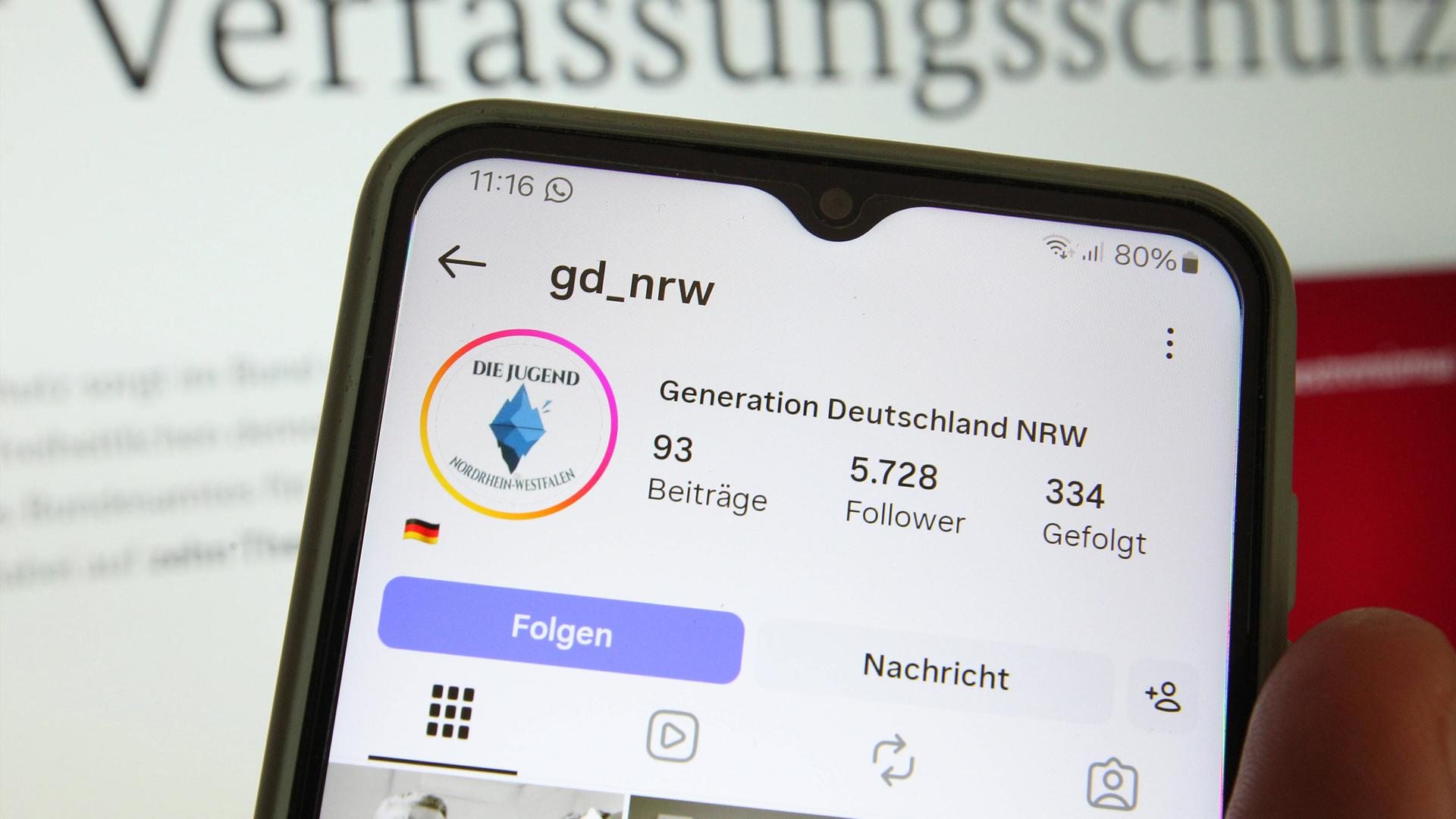 Symbolbild: Auf einem Smartphone wurde der Instagram-Account der "Generation Deutschland" Nordrhein-Westfalen (GD NRW) aufgerufen. Dahinter wurde die Website vom Bundesamt für Verfassungsschutz aufgerufen. 