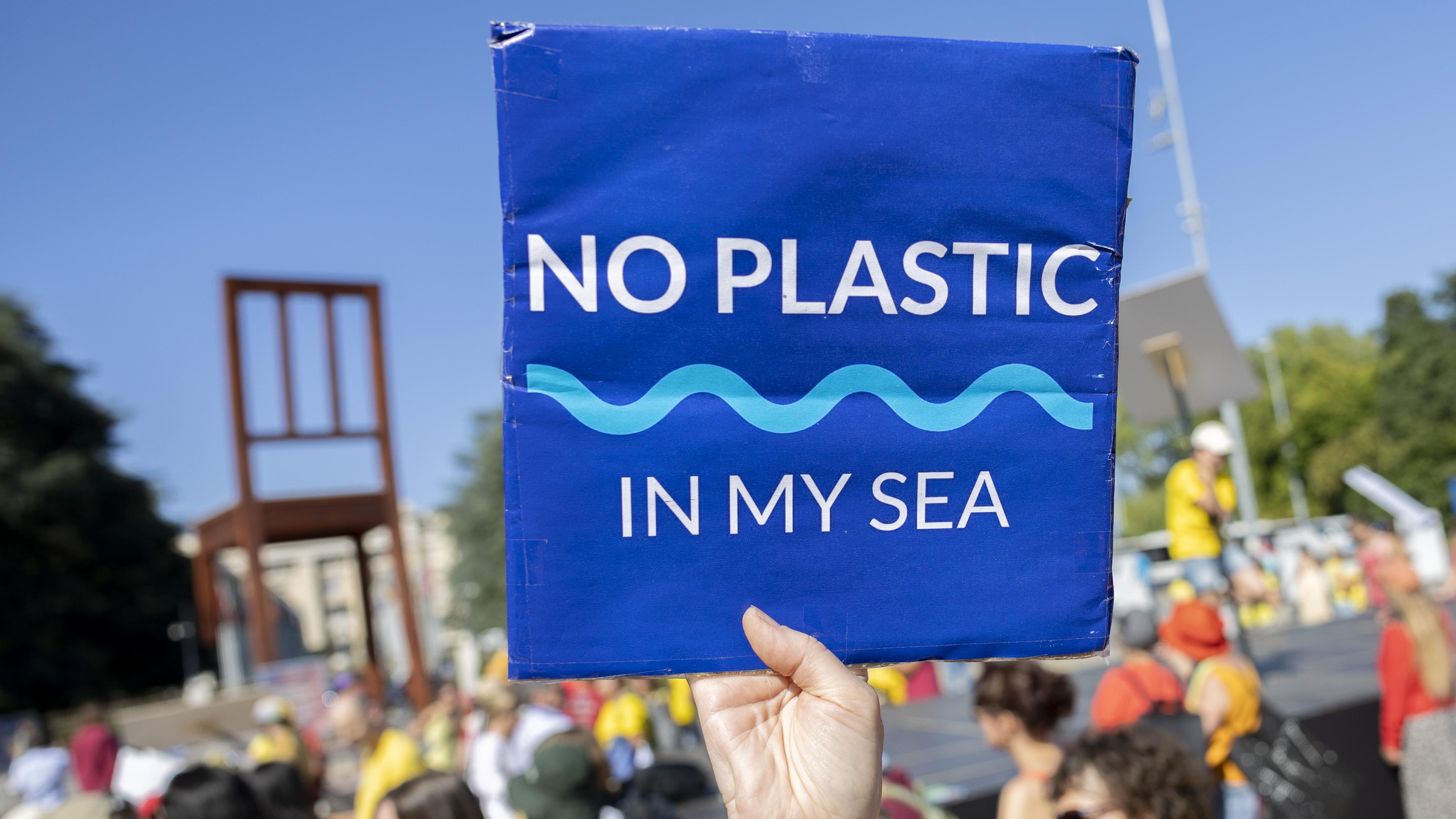 Menschen demonstrieren für ein UN-Plastikabkommen in Genf.