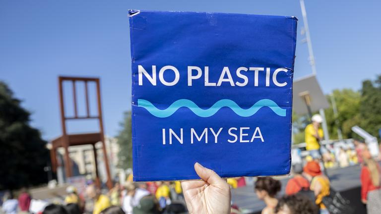 Menschen demonstrieren für ein UN-Plastikabkommen in Genf.