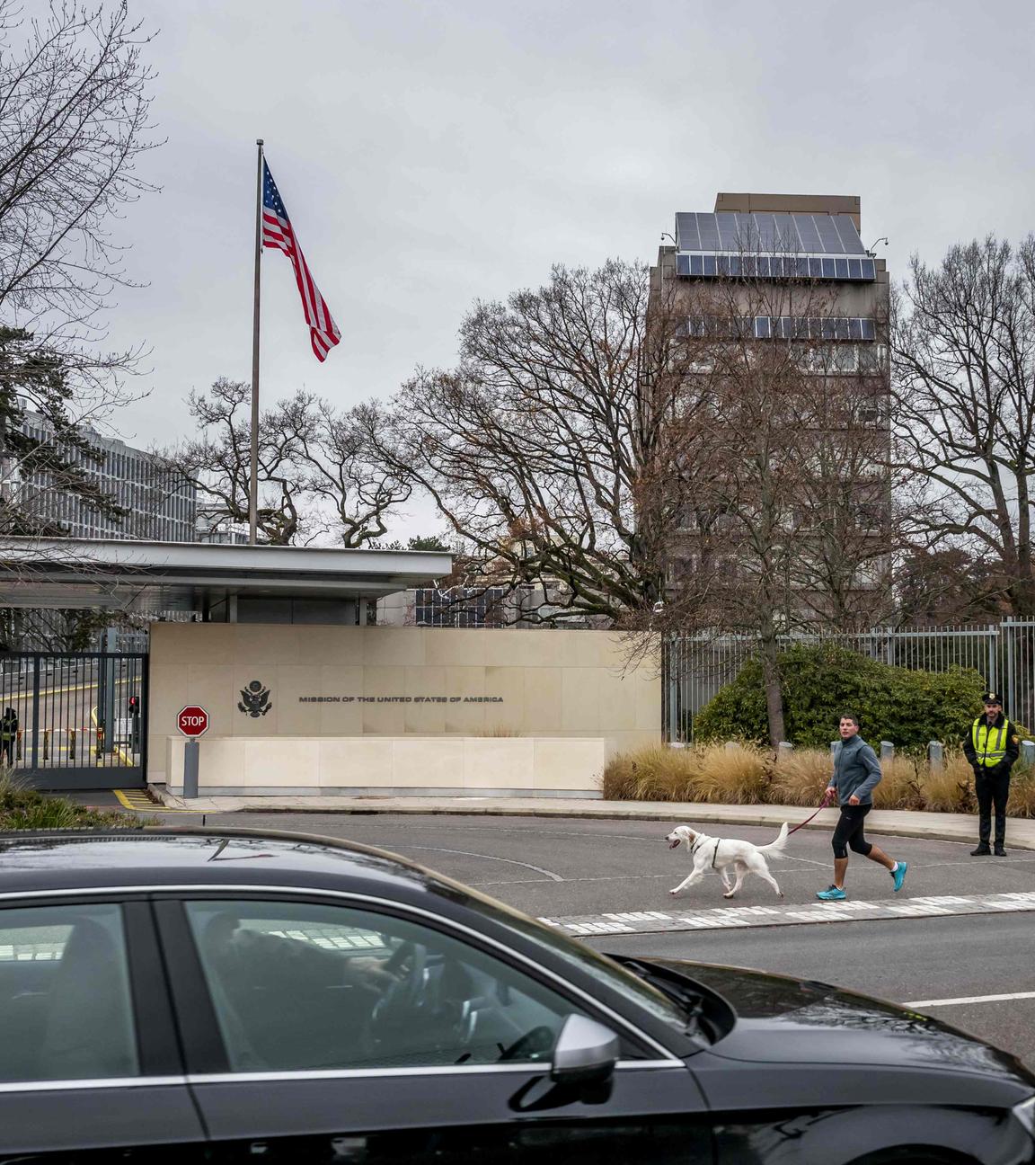 Ein Mann joggt am 23. November 2025 mit seinem Hund vor dem Gebäude der US-Botschaft in Genf, kurz vor den Gesprächen über einen US-Plan zur Beendigung des Ukraine-Krieges. US-Außenminister Marco Rubio traf am Morgen des 23. November 2025 in Genf ein, um über den umstrittenen Vorschlag zu verhandeln, nachdem Washington Verhandlungsbereitschaft signalisiert hatte.