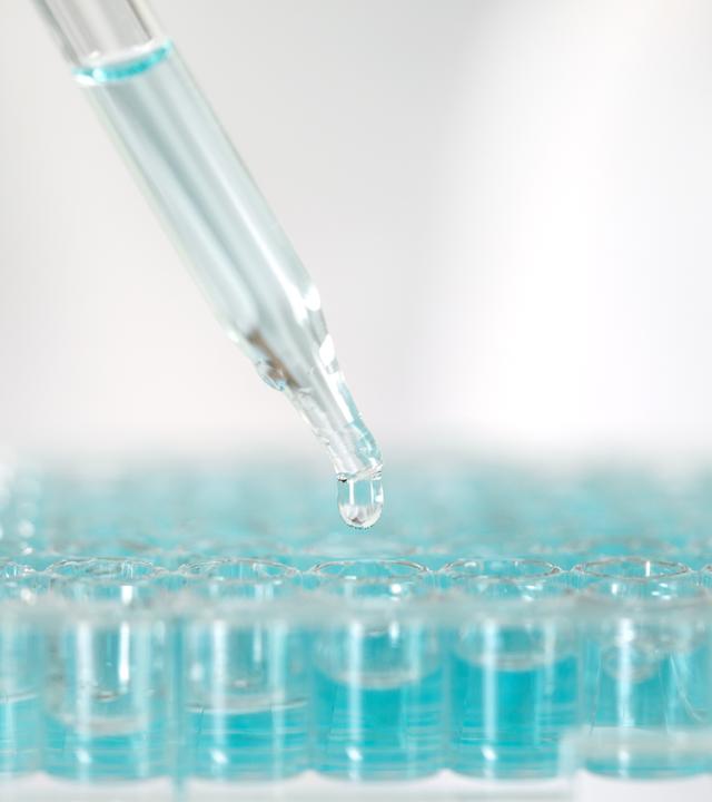 Close up a scientist working in laboratory to analyze blue extracted of DNA molecules in micro tube plate , clinical or science testing analysis concept