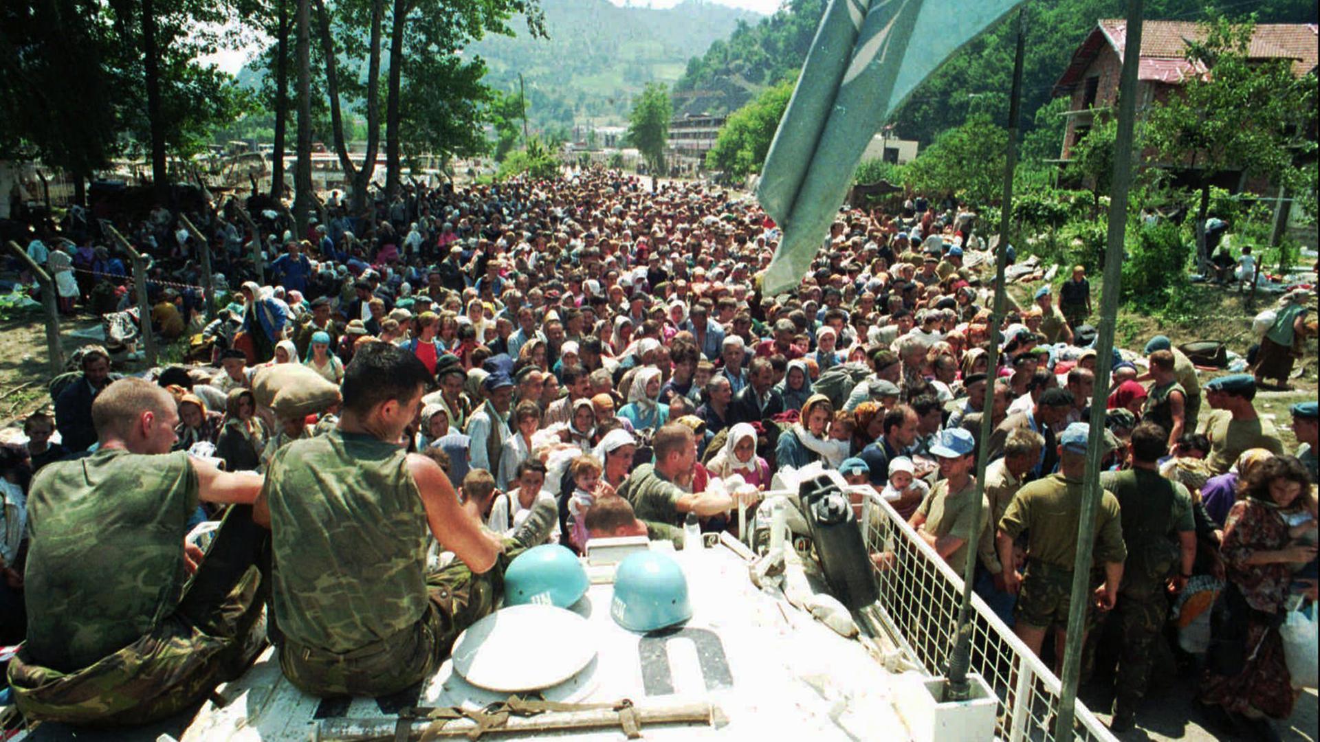 Flüchtlinge aus Srebrenica vor einem Panzerwagen der UN am 13. Juli 1995.