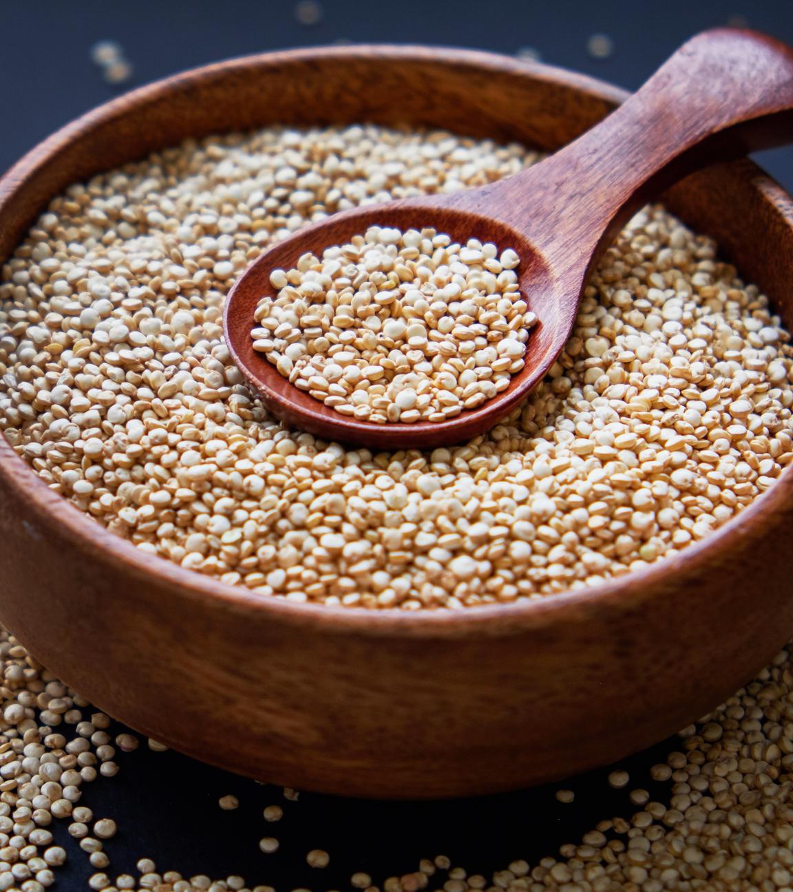 Quinoa in einer Holzschüssel mit einem Löffel