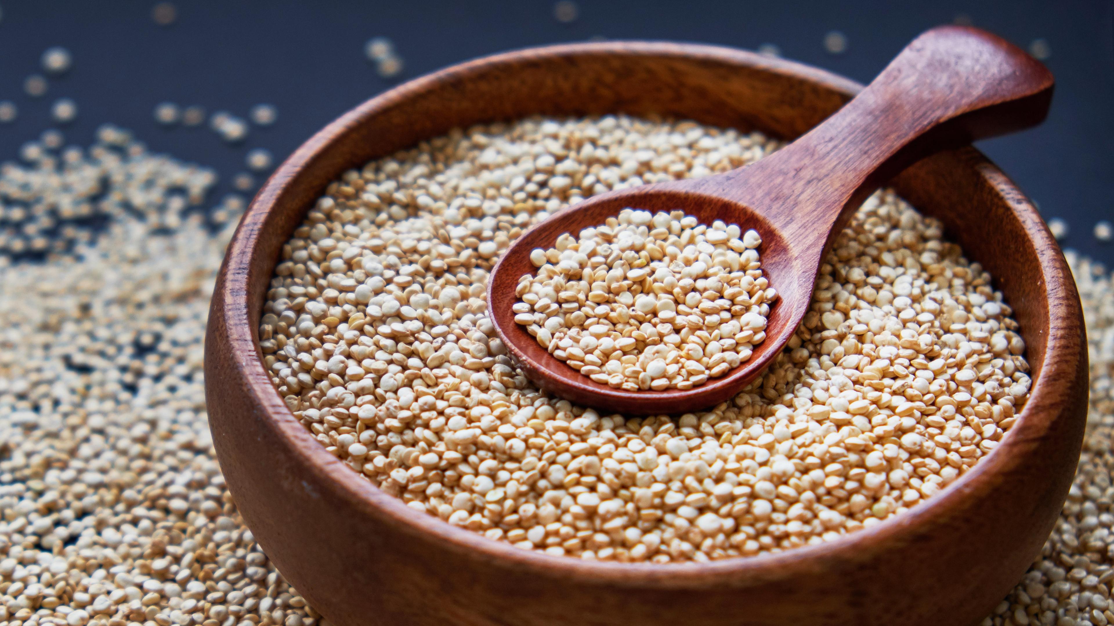 Quinoa in einer Holzschüssel mit einem Löffel