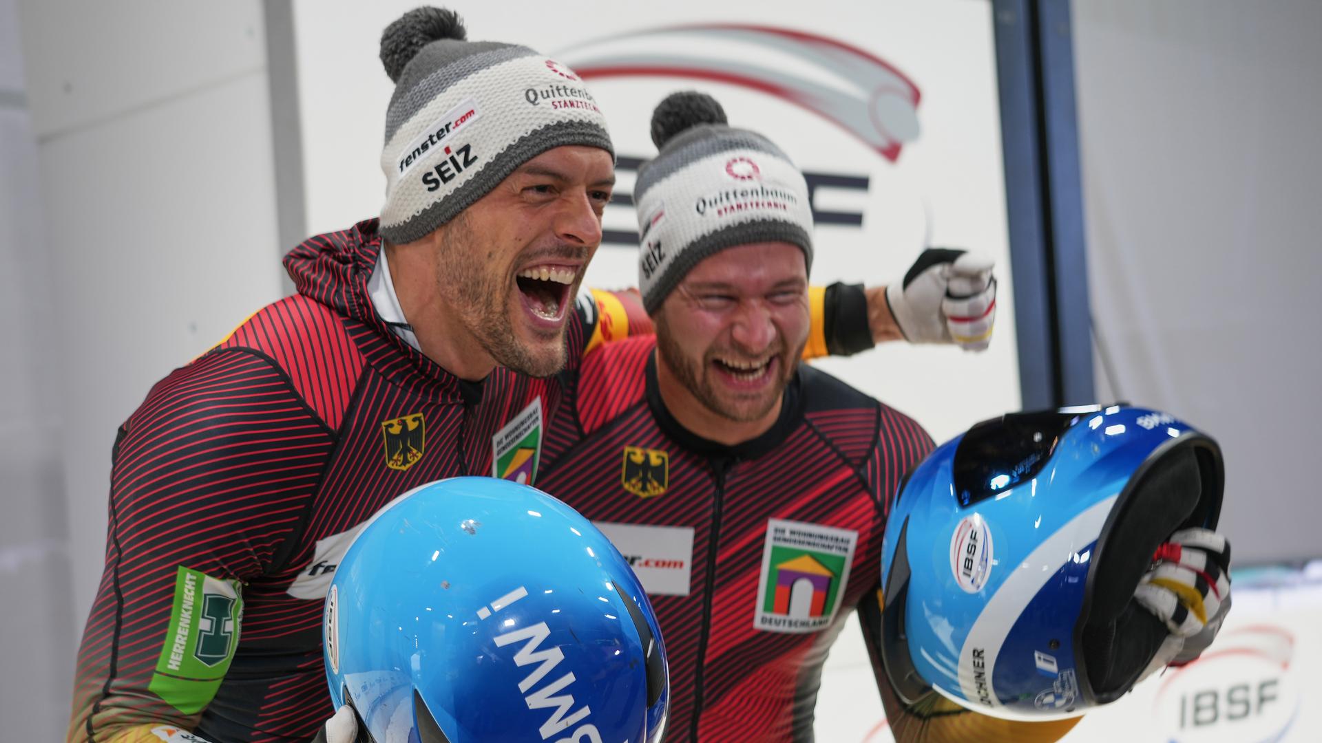 Georg Fleischhauer (links) und Johannes Lochner aus Deutschland feiern nach ihrem ersten Platz beim Weltcup und olympischen Testwettkampf im Zweierbob in Cortina d'Ampezzo, Italien, am 22.11.2025. 
