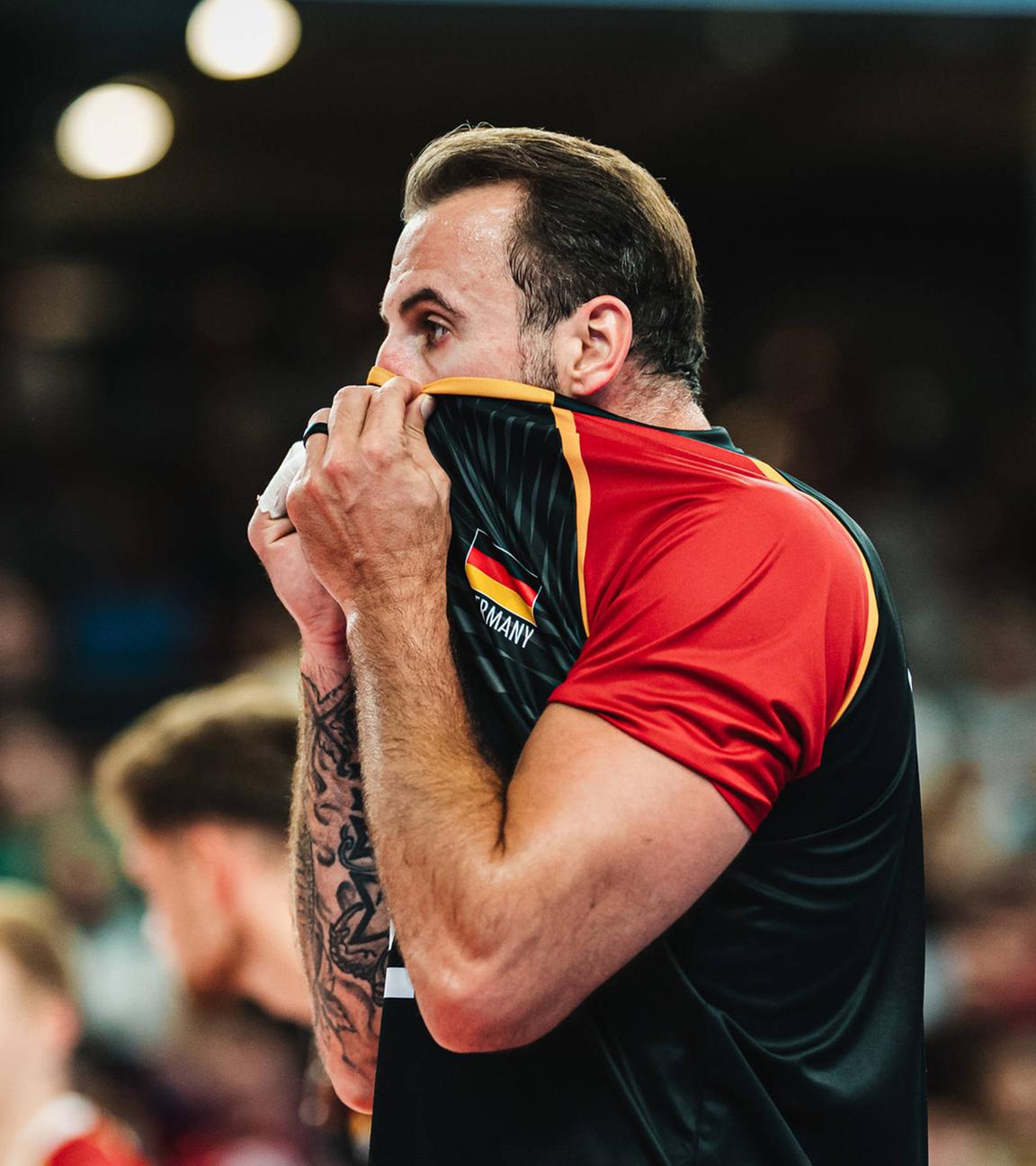 Georg Grozer (Deutschland, 9) zieht sich beim Volleyball-Länderspiel gegen Belgien am 23.08.2025 in der LKH-Arena Lüneburg das Trikot über den Kopf.