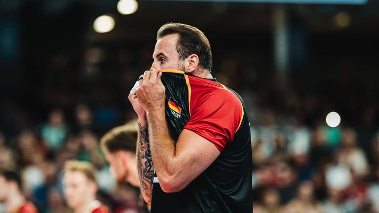 Georg Grozer (Deutschland, 9) zieht sich beim Volleyball-Länderspiel gegen Belgien am 23.08.2025 in der LKH-Arena Lüneburg das Trikot über den Kopf.