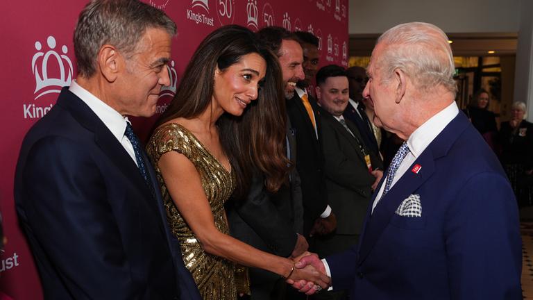 George und Amal Clooney schütteln König Charles die Hand.
