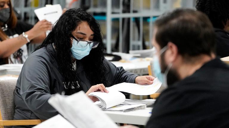 Beamte arbeiten am Freitag, dem 6. November 2020, in Lawrenceville bei Atlanta an Stimmzetteln im Hauptquartier für Wählerregistrierung und Wahlen in Gwinnett County, Georgia, USA