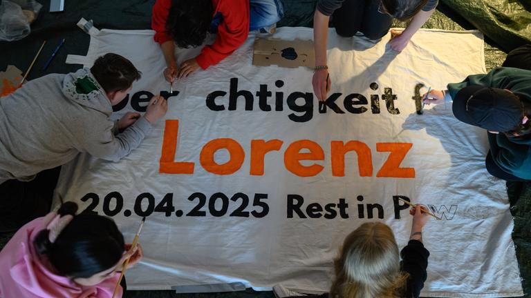 Mitglieder des Bündnisses United against Racism beschriften ein Transparent für die Kundgebung Gerechtigkeit für Lorenz.