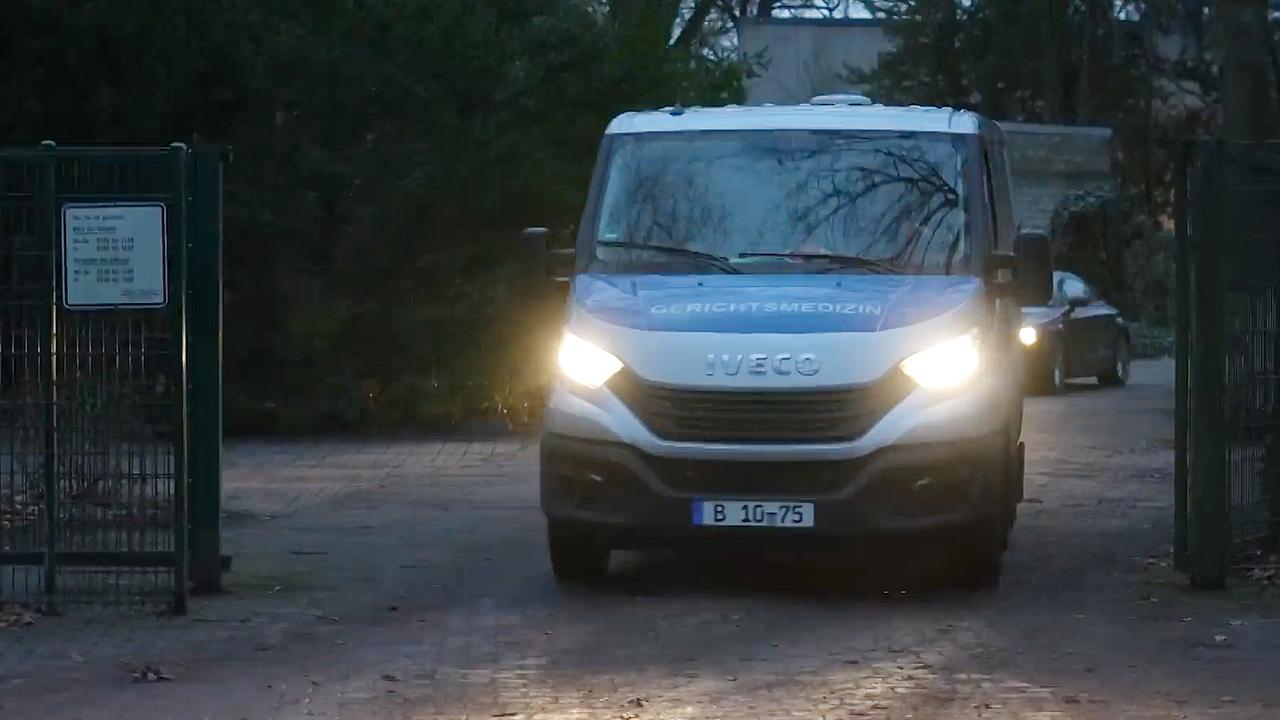 Ein Fahrzeug der Gerichtsmedizin verlässt einen Friedhof.