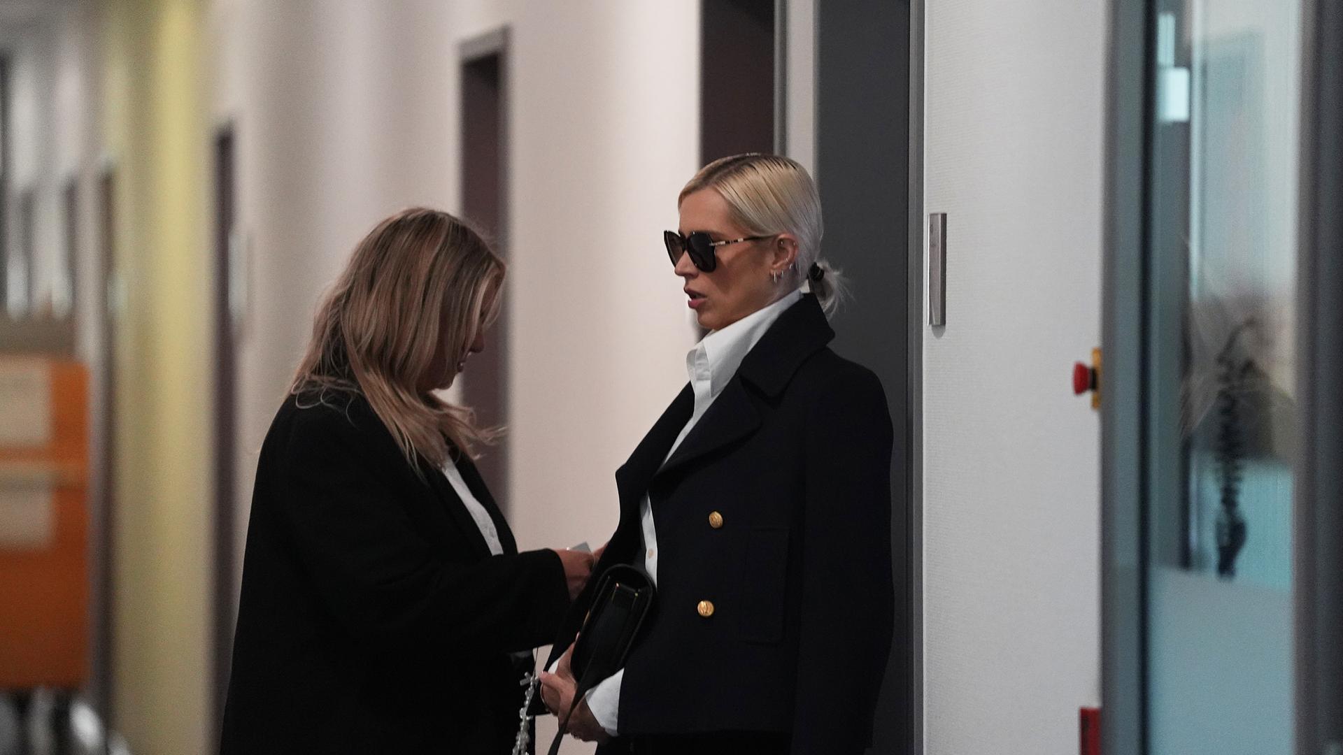 Zwei Frauen, rechts Marc Terenzis Ex-Verlobte Verena Kerth, stehen nach der Zeugenaussage gegen Marc Terenzi in einem Gang mit mehreren Türen im Amtsgericht St. Georg.