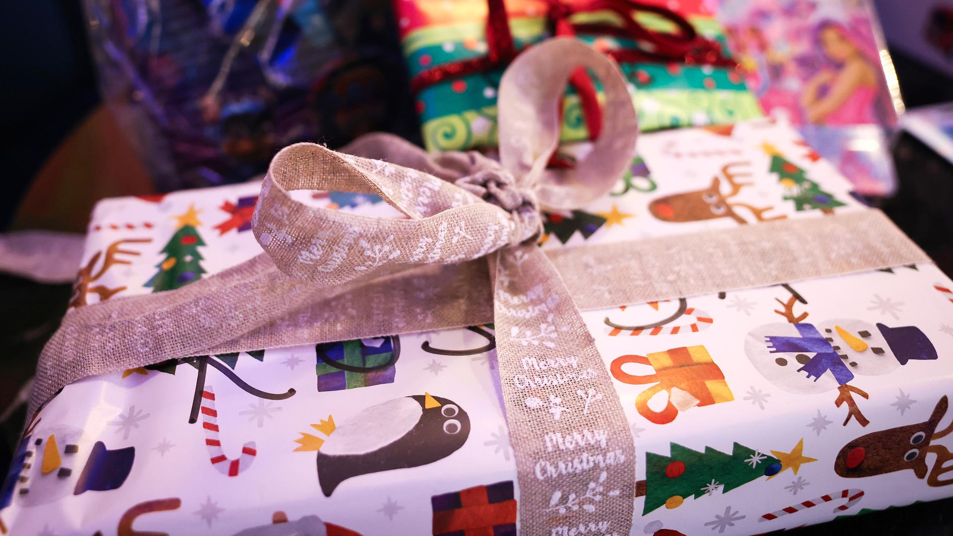 Weihnachtlich verpackte Geschenke liegen auf einem Tisch.