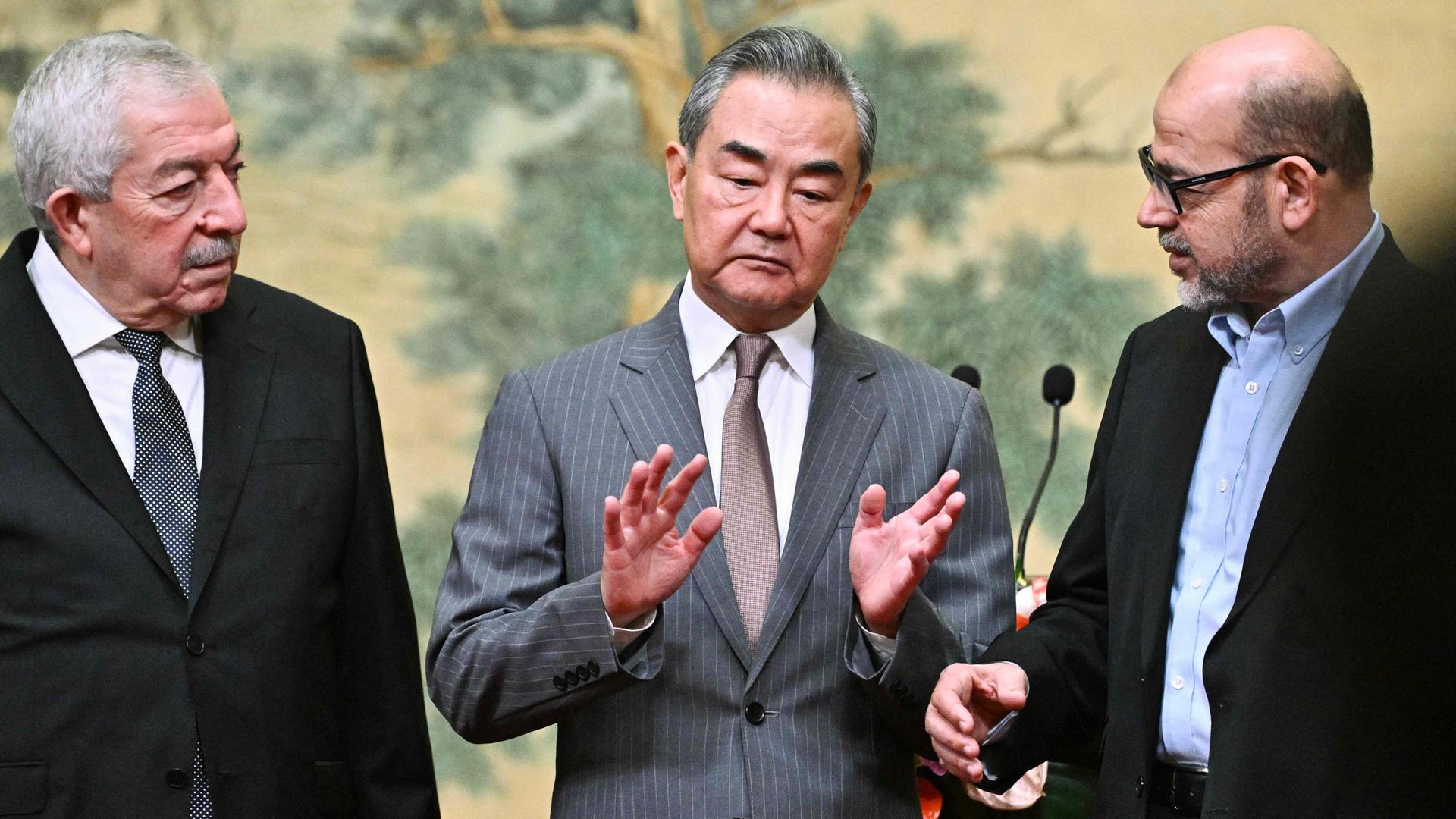 (L-R) Mahmoud al-Aloul (Fatah), Chinas Außenminister Wang Yi und Mussa Abu Marzuk (Hamas) am 23.07.2024 in Peking (China)