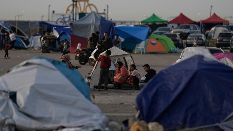15.04.2026, Libanon, Beirut: Menschen, die vor den israelischen Angriffen auf die als Dahija bekannten südlichen Vororten Beiruts geflohen sind, sitzen vor Zelten, die als Unterkunft dienen.