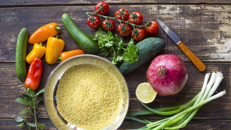 Zutaten für einen Bulgursalat: Bulgur, Paprika, Zucchini, Tomaten, Avocado, Granatapfel, Frühlingszwiebeln, Zitrone, Kräuter