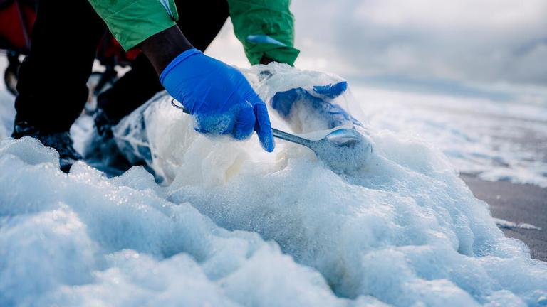 Dr. Julios Kontchou, Ökotoxikologe von Greenpeace, entnimmt auf der norddeutschen Insel Sylt Proben von Meeresschaum, um sie auf PFAS (Per- und Polyfluoralkyl-Stoffe) - die so genannten Ewigkeitschemikalien - untersuchen zu lassen.