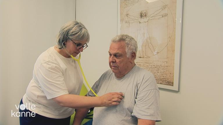 Herzschlag von älterem Mann wird von einer Ärztin abgehört