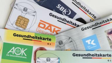 Gesundheitskarten verschiedener Krankenkassen auf einem Tisch, Archivbild