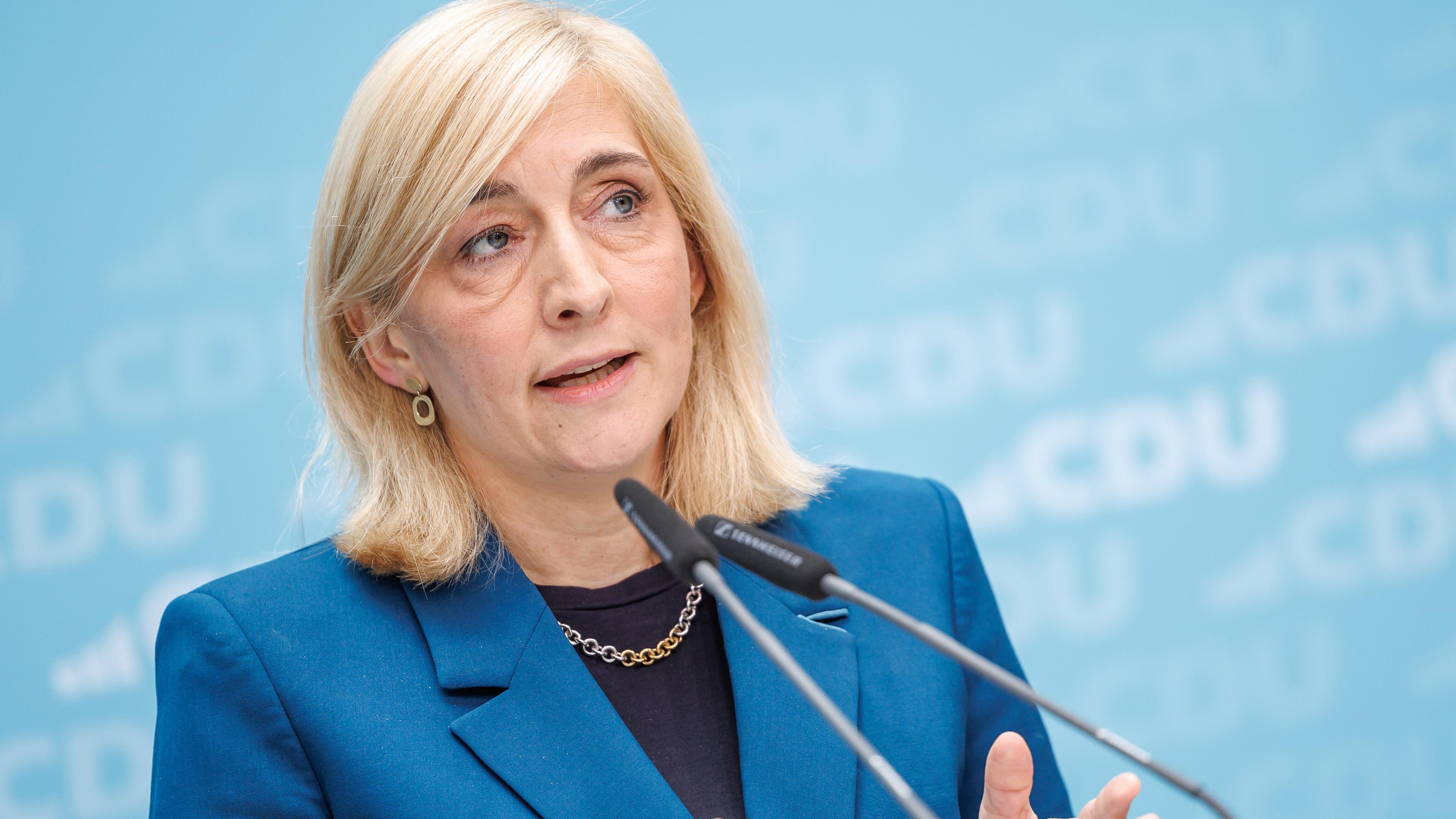 Gesundheitsministerin Nina Warken vor einem blauen Hintergrund mit CDU Logos